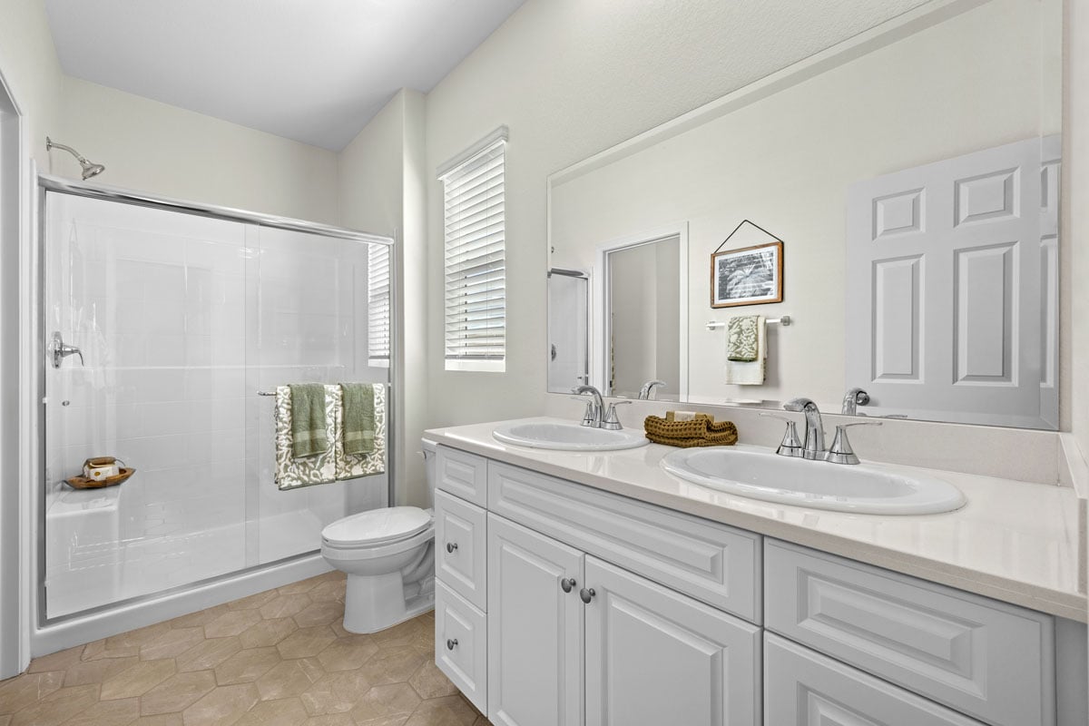 Walk-in shower with clear glass enclosure at primary bath