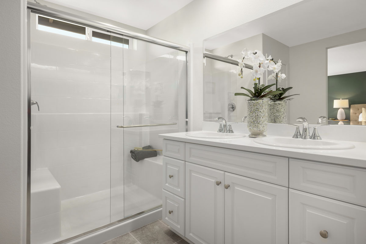 Walk-in shower with clear glass enclosure at primary bath