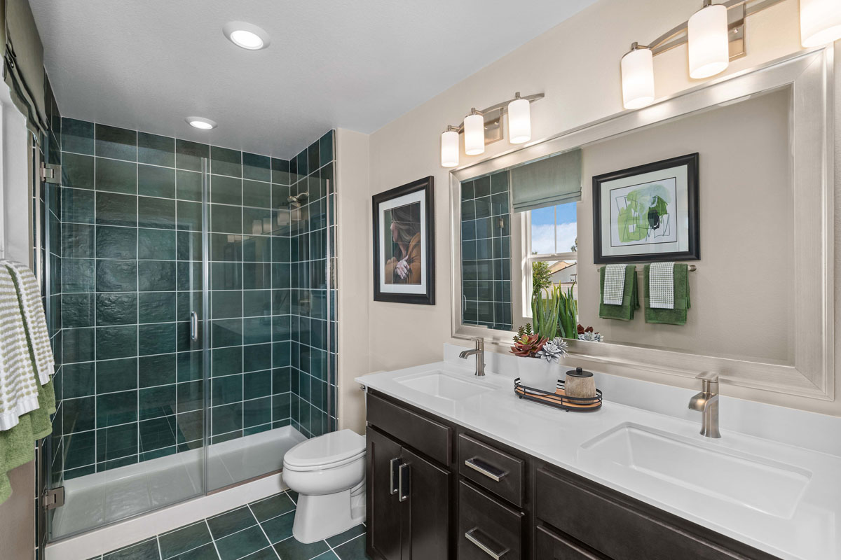 Walk-in fiberglass shower with tile surround at primary bath