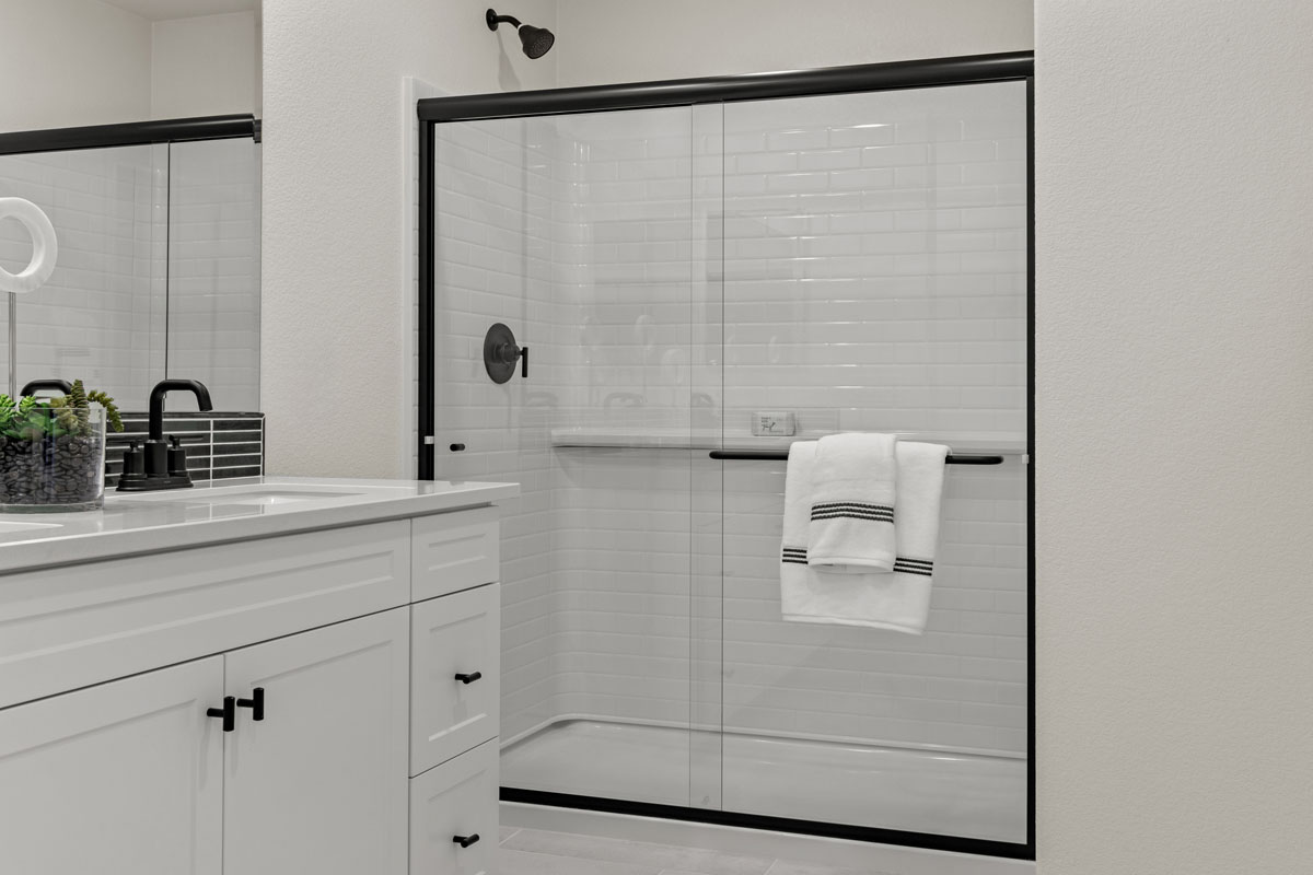 Walk-in shower with clear glass enclosure at primary bath