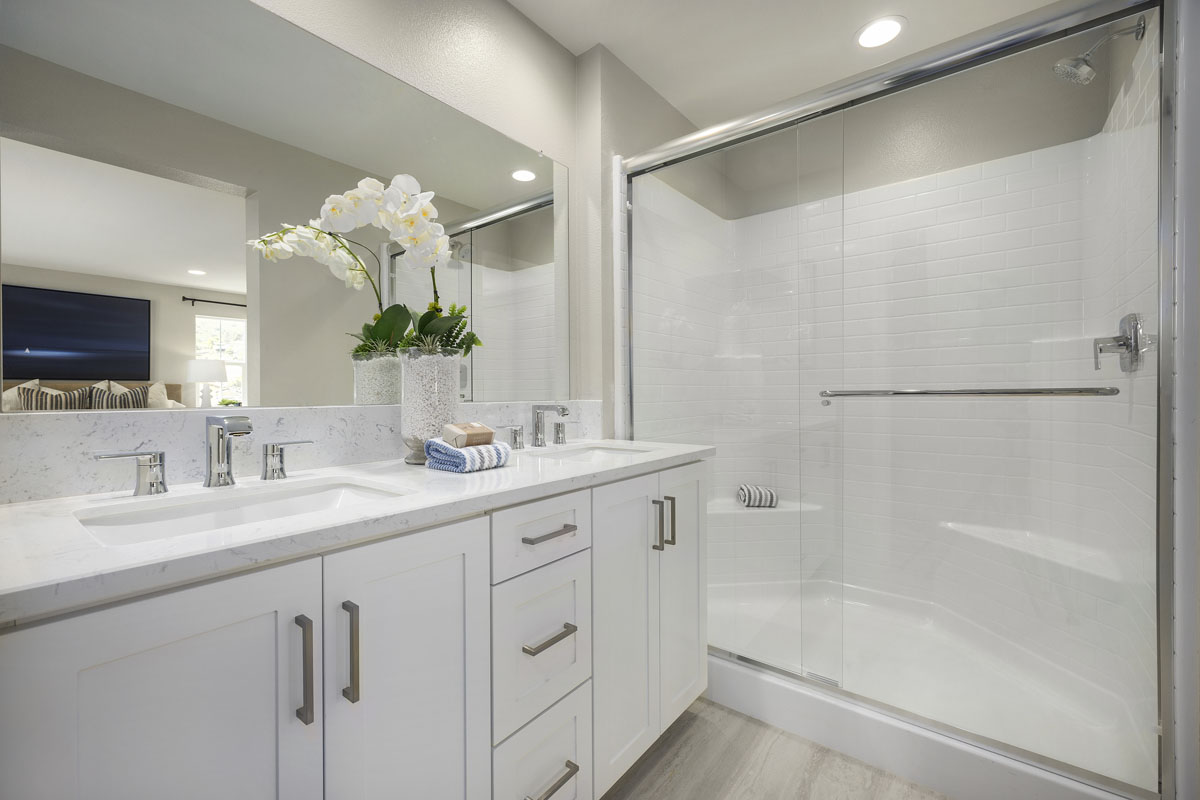 Walk-in shower with clear glass enclosure at primary bath