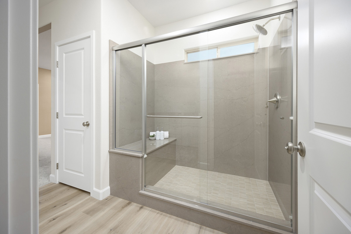 Enlarged walk-in shower with seat at primary bath